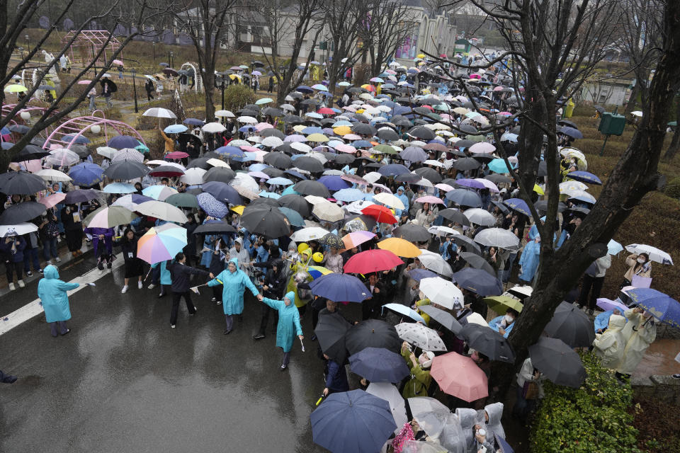 Visitors gather to see a vehicle carrying Fu Bao, the first giant panda born in South Korea, before she was transferred to the airport for China at the Everland amusement park in Yongin, South Korea, Wednesday, April 3, 2024. (AP Photo/Lee Jin-man)