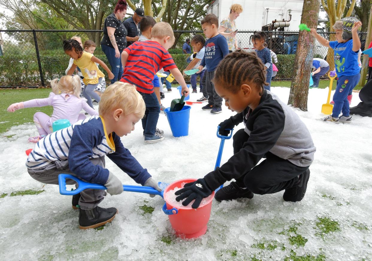 As other children play, Luke Bailey (from left) and Aven Charlton, both 3, work together to fill a bucket with crushed ice during a 2020 snow day at the Bright Horizons at the Avenues child care center.