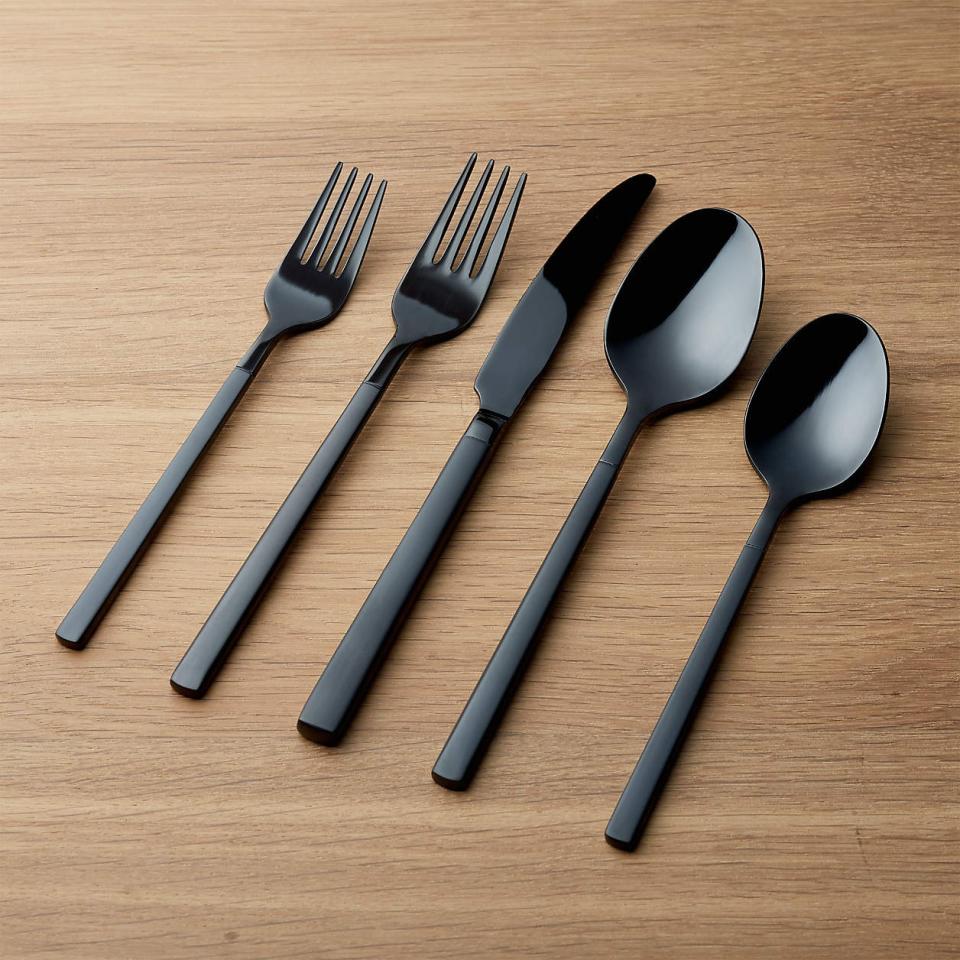 Five pieces of black silverware on wood table