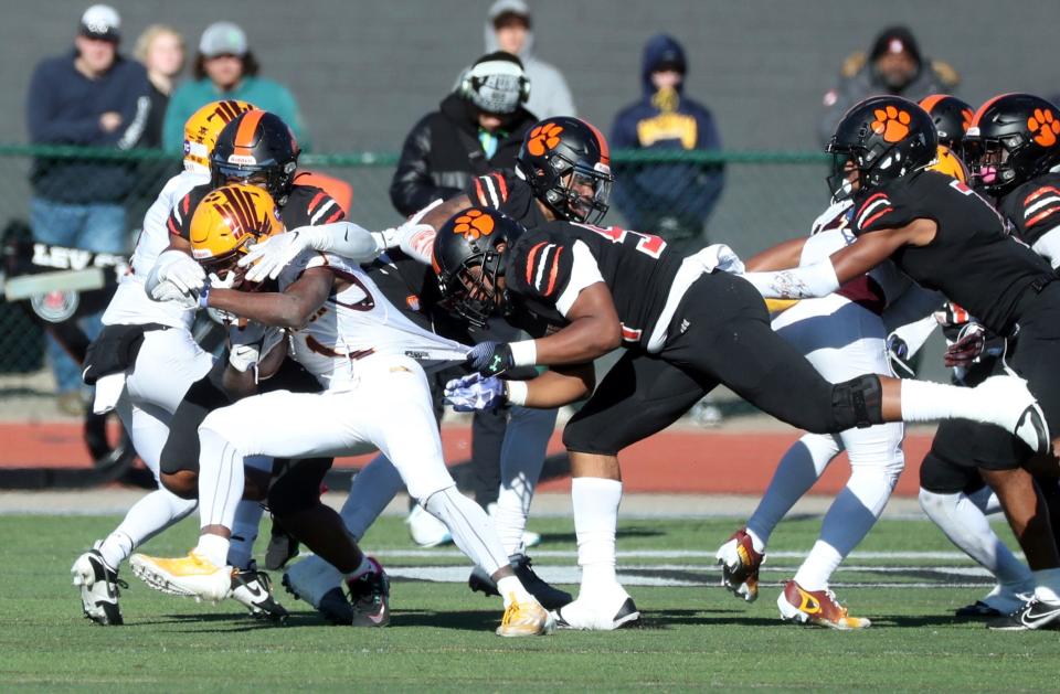 Belleville defenders tackle Davison running back AJ Hill during first-half action at Novi High School on Saturday, Nov. 18, 2023.