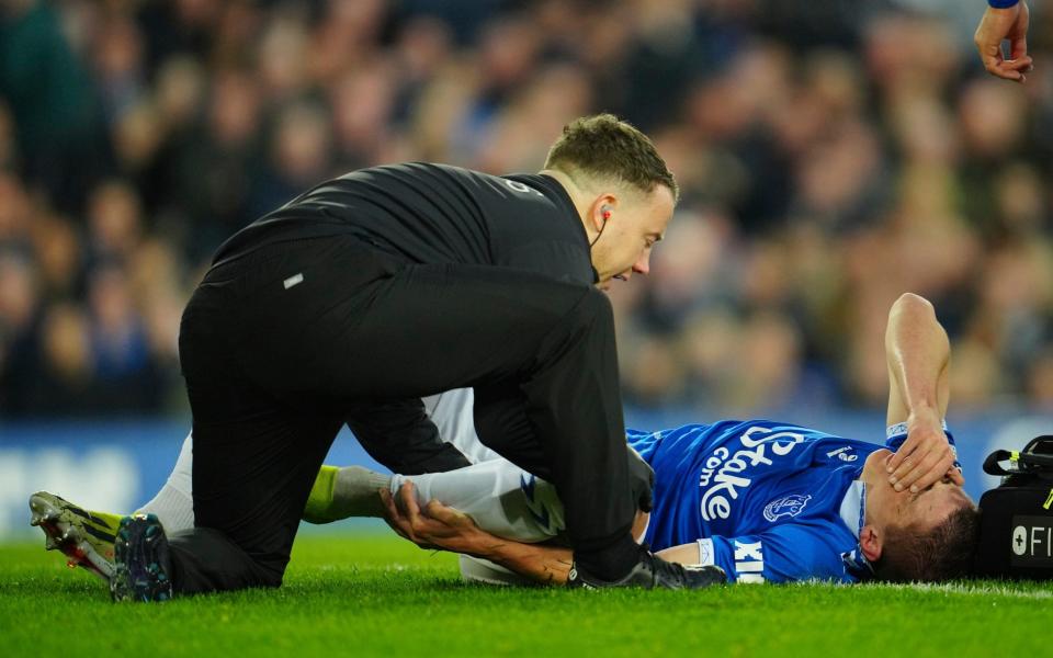 Everton's Vitaliy Mykolenko is assisted during the English Premier League soccer match between Everton and Liverpool