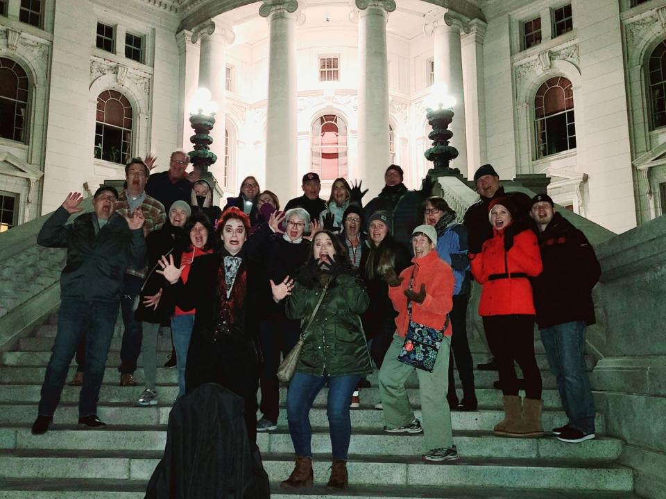 A tour group poses on the steps of the Wisconsin State Capitol building in Madison on the King St. and Capitol Square ghost walk offered by American Ghost Walks.