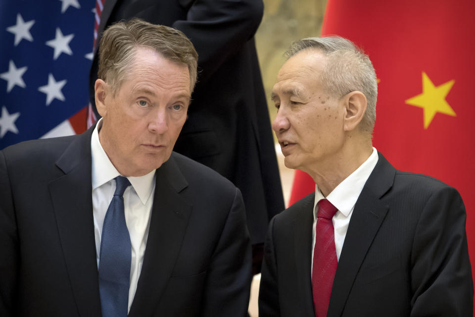 FILE - In this Feb. 15, 2019, file photo, Chinese Vice Premier Liu He, right, talks with U.S. Trade Representative Robert Lighthizer, while they line up for a group photo at the Diaoyutai State Guesthouse in Beijing. China's economy czar is going to Washington for talks Thursday and Friday aimed at ending a tariff war over Beijing's technology ambitions.(AP Photo/Mark Schiefelbein, File)