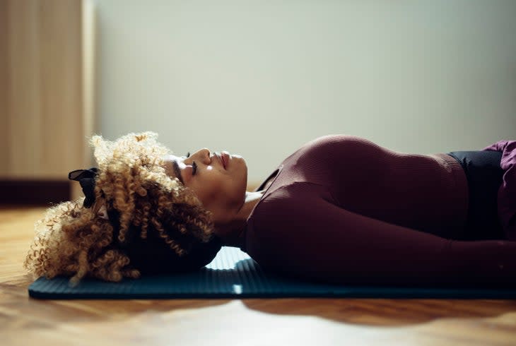 woman lying on the yoga mat on the floor