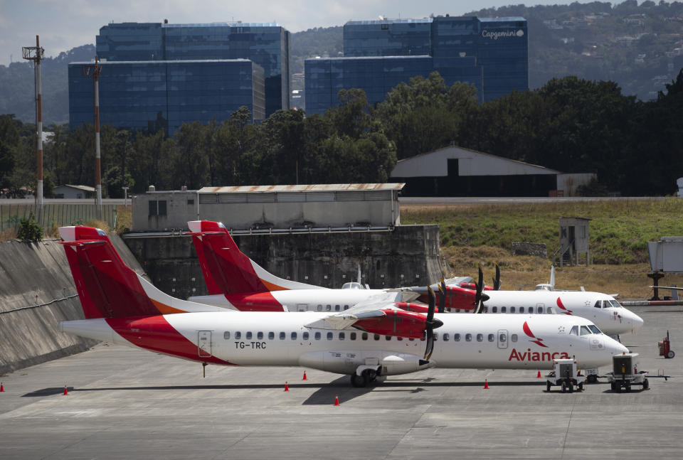 ARCHIVO - En esta foto de archivo del 17 de marzo de 2020, aviones de la aerolínea Avianca estacionados en el aeropuerto La Aurora en Ciudad de Guatemala. La Aeronáutica Civil de Colombia ratificó el 8 de mayo de 2023 la integración de las empresas Avianca, Viva Air y Viva Air Perú. (AP Foto/Moisés Castillo, Archivo)