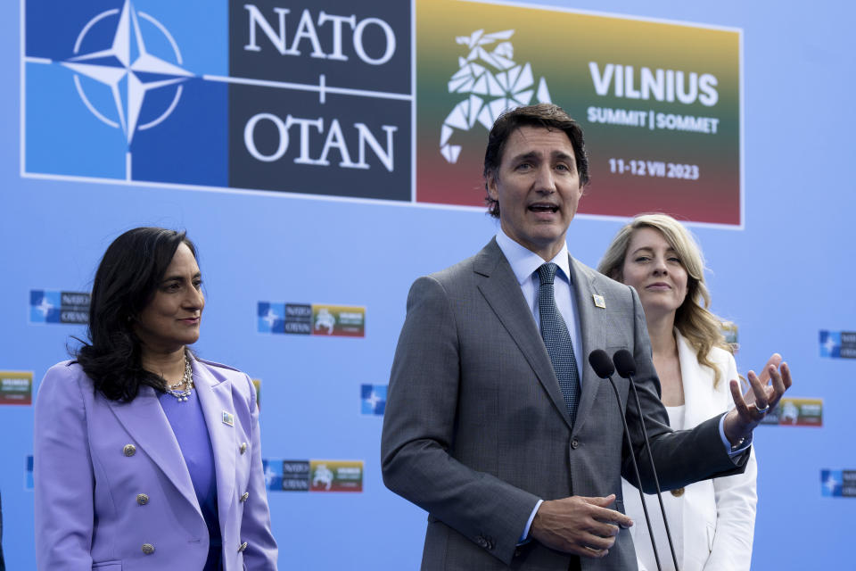 Flanked by Canada Minister of Defense Anita Anand and Foreign Affairs Minister Melanie Joly, Prime Minister Justin Trudeau speaks to media at the NATO Summit, Tuesday, July 11, 2023, in Vilnius, Lithuania. (Adrian Wyld/The Canadian Press via AP)