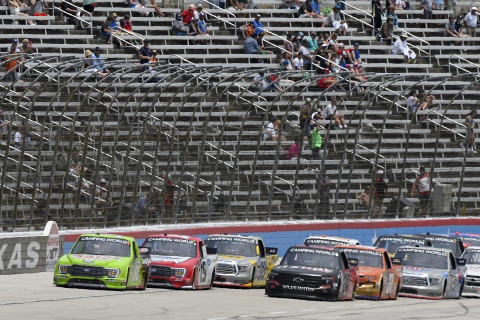 Todd Gilliland, left front, and Chase Elliott, right front, lead the field into the front stretch coming out of Turn 4 during a NASCAR Truck Series auto race at Texas Motor Speedway in Fort Worth, Texas, Saturday, June 12, 2021. (AP Photo/Larry Papke)