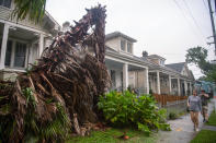 People walk along a sidewalk in New Orleans as the outer eye wall of Hurricane Zeta passed by the city, Wednesday, Oct. 28, 2020. (Chris Granger/The Times-Picayune/The New Orleans Advocate via AP)