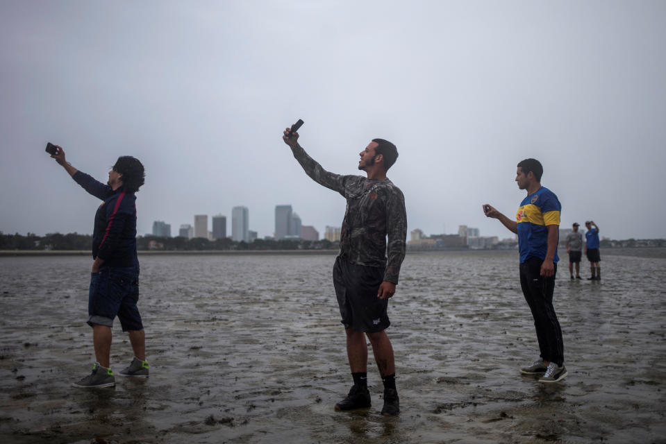 <p>Rony Ordonez, Jean Dejesus und Henry Gallego, drei Bewohner von Tampa in Florida, machen vor dem Eintreffen des Hurrikans noch Fotos auf dem Strandabschnitt Hillsborough Bay. Die komplette Tampa-Bay-Region wurde am Montagmorgen von „Irma“ mit erfasst. Allerdings hat der Wirbelsturm an Kraft verloren. Dennoch sind die Windgeschwindigkeiten von 135 Stundenkilometer nach wie vor extrem gefährlich. (Bild: REUTERS/Adrees Latif) </p>