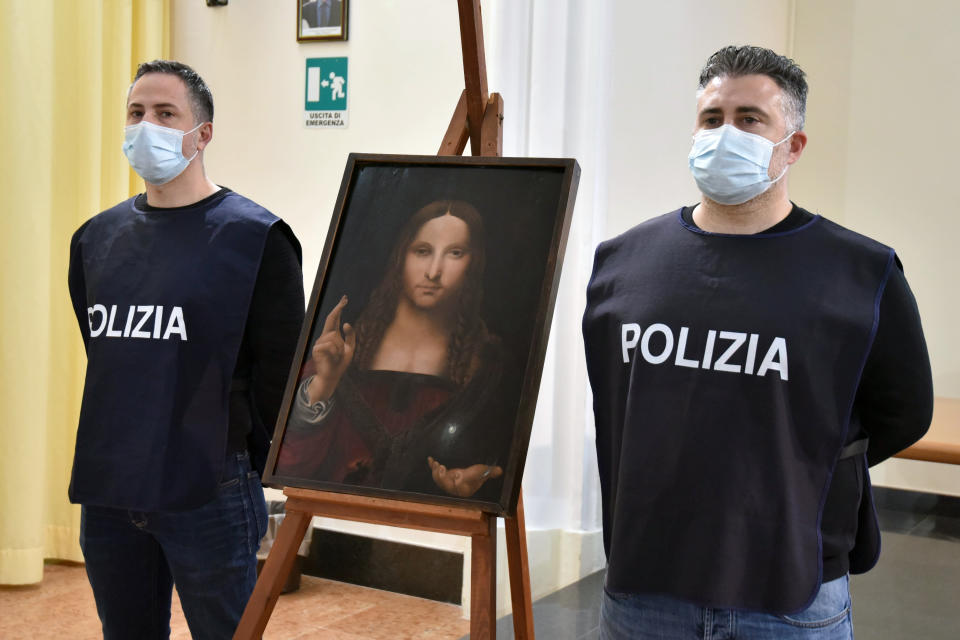 Italian police officers stand by a copy of the “Salvator Mundi” (Savior of the World) by Leonardo da Vinci, in Naples, Italy, Wednesday, Jan. 20, 2021. Italian police have recovered a copy of Leonardo da Vinci’s 16th century “Salvator Mundi” painting of Jesus Christ that was stolen from a Naples church without the priests even realizing it was gone. The discovery was made over the weekend when Naples police working on a bigger operation found the painting hidden in an apartment. Police chief Alfredo Fabbrocini said the owner offered a “less than credible” explanation that he had “casually” bought it at a small market. (Italian Police via AP)