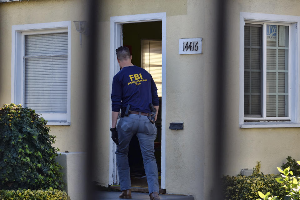 An FBI evidence response team agent enters a building on the grounds of the Kingdom of Jesus Christ Church in the Van Nuys section of Los Angeles on Wednesday, Jan. 29, 2020. The FBI raided a Philippines-based church in Los Angeles to arrest leaders of an alleged immigration fraud scheme that resulted in sham marriages. Federal prosecutors said Wednesday that three leaders of the local branch of the Kingdom of Jesus Christ were arrested in morning raids. (AP Photo/Richard Vogel)