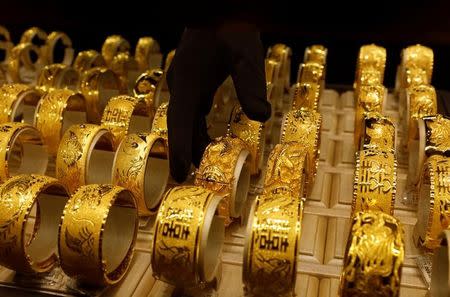 A salesperson arranges 24K gold bracelets for Chinese weddings at Chow Tai Fook Jewellery store in Hong Kong, China December 14, 2017. REUTERS/Tyrone Siu/Files