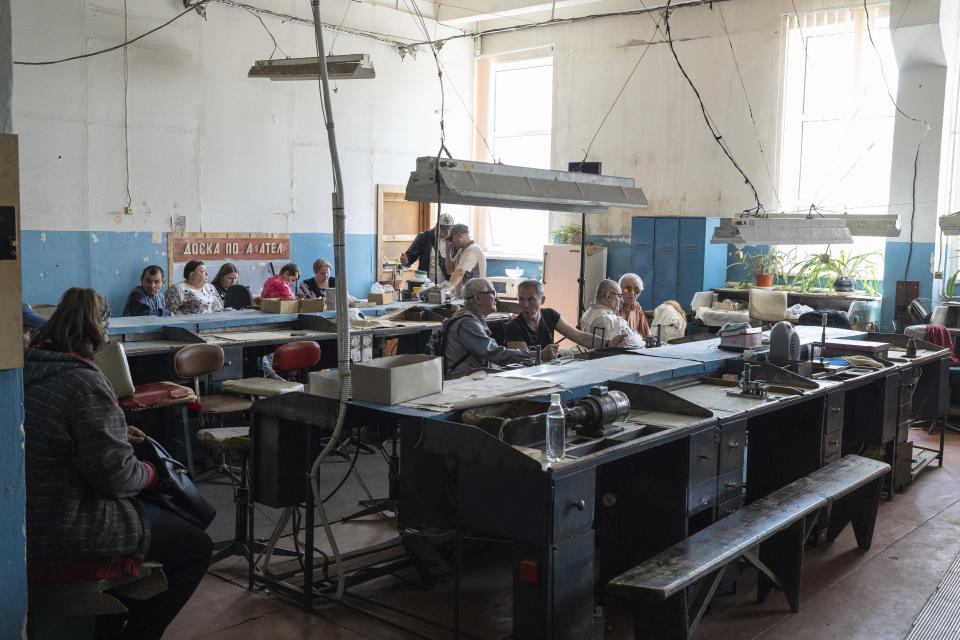 People sit in a workshop in Kyiv, Ukraine, May 30, 2023, in a manufacturing plant where visually impaired people used to work until it was shuttered following a Russian air assault. Losing the place of work is just one of a multitude of challenges that people with visual impairments face across Ukraine since Russia launched a full-scale invasion in February 2022. (AP Photo/Roman Hrytsyna)