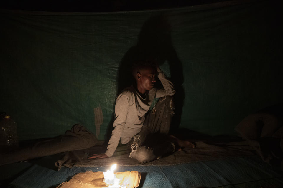 Abedom, a 25-year-old day laborer and Tigrayan refugee, sits for a portrait inside his friends' shelter in Hamdayet, eastern Sudan, near the border with Ethiopia, on March 16, 2021. Abedom spent three months roaming in mountains and rural villages. "It was normal to go a whole day without food. So many people were hungry. They loot everything, so if they take it all, how do I survive?" (AP Photo/Nariman El-Mofty)