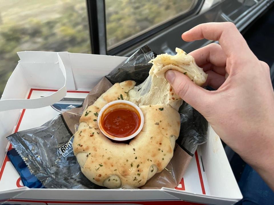 the writer ulling cheese off a cheese stromboli on  amtrak train
