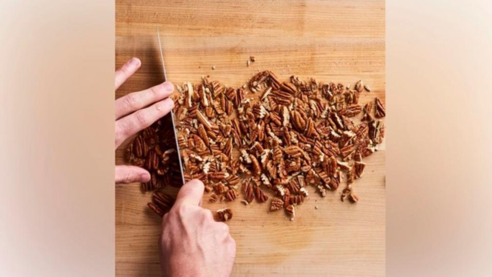 knife chopping pecans on kitchen counter