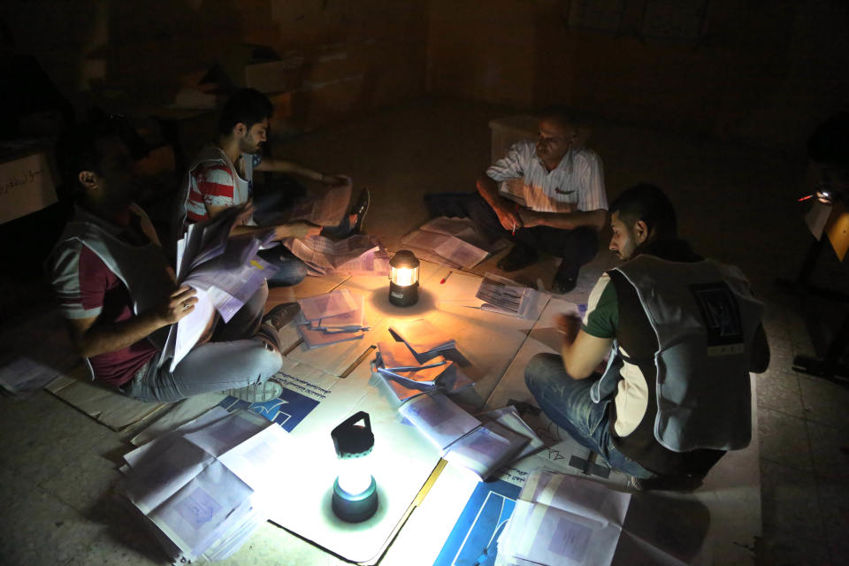 Electoral workers count ballots under lamplight due to a power cut, as polls close at a polling center in Basra, Iraq's second-largest city, 340 miles (550 kilometers) southeast of Baghdad, Iraq, Wednesday, April 30, 2014. Iraqis braved the threat of bombs and other violence to vote Wednesday in parliamentary elections amid a massive security operation as the country slides deeper into sectarian strife. (AP Photo/ Nabil al-Jurani)