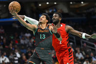 Washington Wizards guard Jordan Poole, left, drives past Portland Trail Blazers center Deandre Ayton for a basket during the first half of an NBA basketball game Friday, April 5, 2024, in Washington. (AP Photo/John McDonnell)