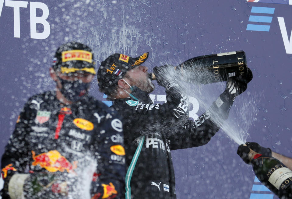 Valtteri Bottas de Mercedes bebe champaña tras ganar el Gran Premio de Rusia de la Fórmula Uno en Sochi, el domingo 27 de septiembre de 2020. (Yuri Kochetkov, Pool Foto vía AP)