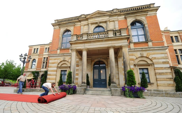 Workers roll out the red carpet in front of the festival house on the 'Green Hill' prior to the Bayreuth music festival in southern Germany