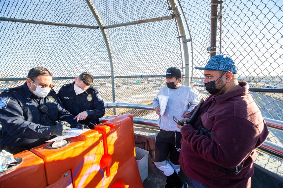 At far right, Mauricio Sanchez, a 29-year-old Nicaraguan, was among those enrolled in Migrant Protection Protocols, also known as 'Remain in Mexico.' A U.S. Customs and Border Protection officers review his COVID-19 test documents prior to allowing him to enter the U.S. at the El Paso del Norte International Bridge in order to attend a court hearing on Jan. 6, 2022.