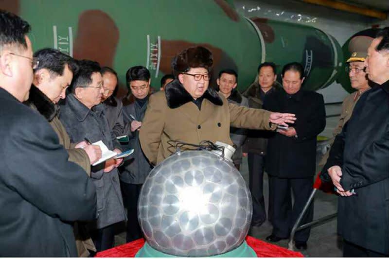北韓領導人金正恩視察小型化的核彈頭。（勞動新聞）