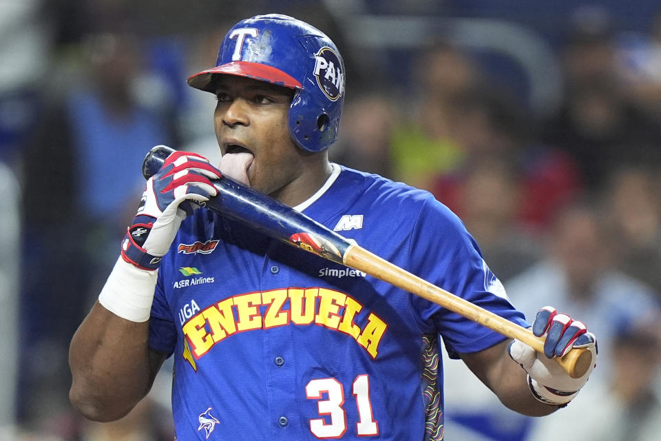 El cubano Yasiel Puig, de Venezuela, lame su bate luego de conectar un batazo de foul en el duelo de la Serie del Caribe ante República Dominicana, el jueves 1 de febrero de 2024 en Miami (AP Foto/Wilfredo Lee)