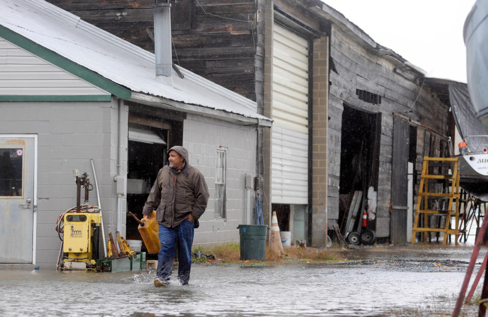 Chris Scarlato of Havre de Grace, Md., carries a gas can in a flooded marina yard in Havre de Grace as the aftermath of superstorm Sandy continues to disrupt routines on the East Coast Tuesday, Oct. 30, 2012. (AP Photo/Steve Ruark)