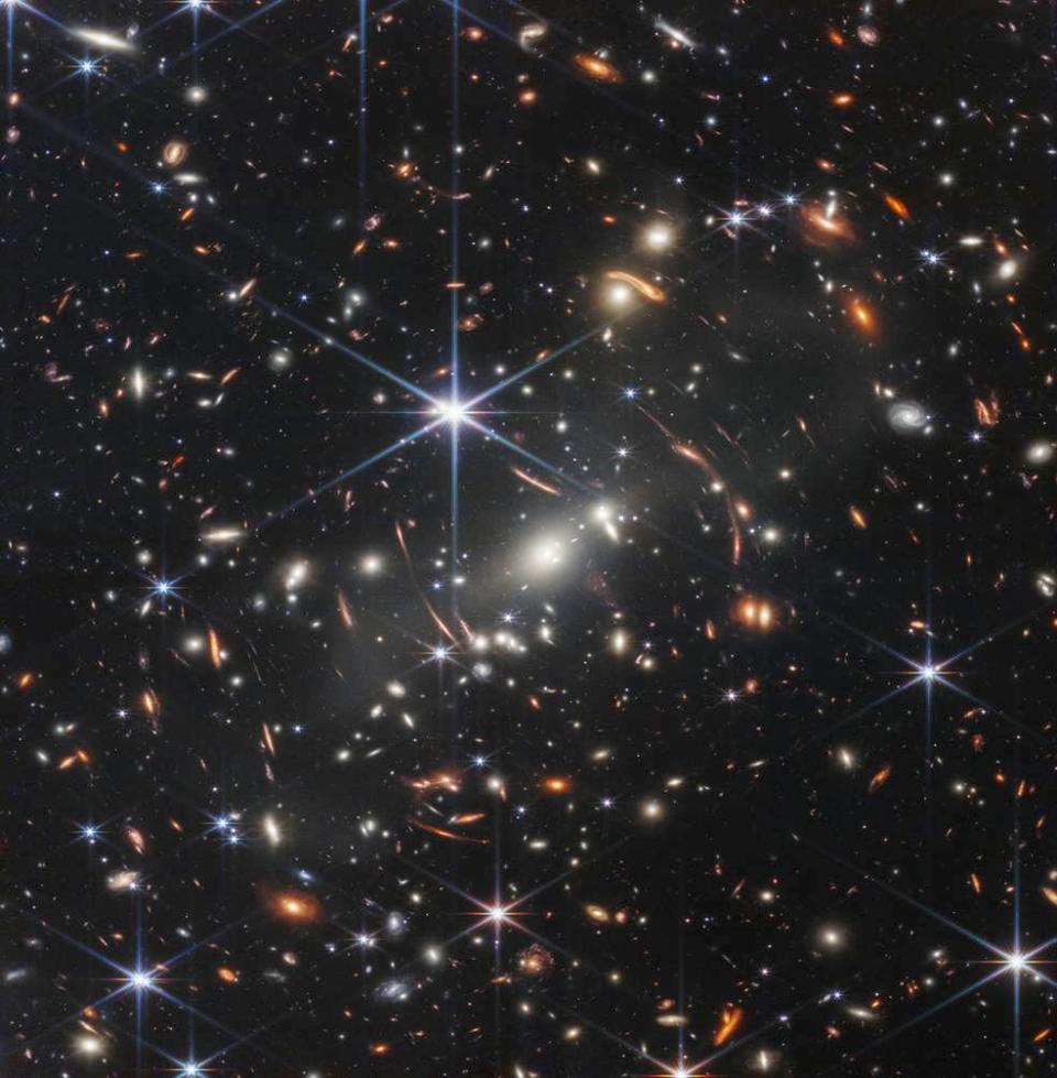 The first publicly released image from the James Webb Space Telescope, showing countless galaxies and multiple arcs where the combined gravity of those galaxies magnifies light from background objects, bringing even more distant galaxies into view.   / Credit: NASA