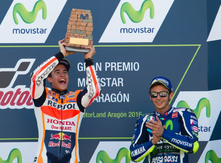 Race winner Marc Marquez (L) celebrates on the podium beside third placed Valentino Rossi at the Aragon MotoGP in Alcaniz on September 25, 2016