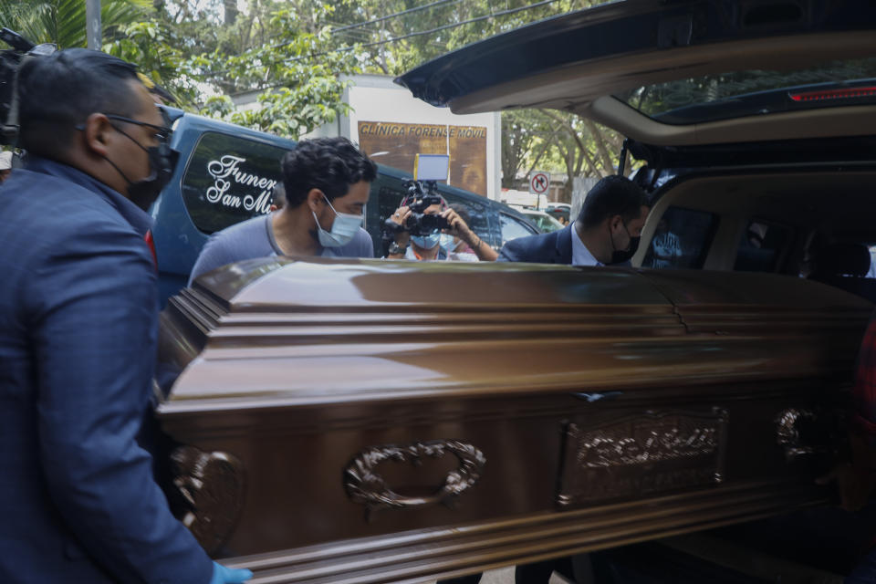 Trabajadores de una funeraria colocan un ataúd con los restos de una reclusa en un coche fúnebre en Tegucigalpa, Honduras, el miércoles 21 de junio de 2023. (AP Foto/Elmer Martínez)