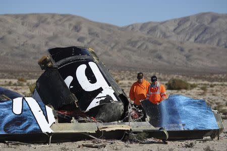 Sheriffs' deputies look at wreckage from the crash of Virgin Galactic's SpaceShipTwo near Cantil, California November 2, 2014. REUTERS/David McNew