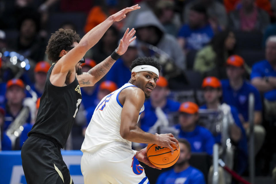 Boise State guard Chibuzo Agbo, right, is defended by Colorado guard J'Vonne Hadley during the second half of a First Four game in the NCAA men's college basketball tournament Wednesday, March 20, 2024, in Dayton, Ohio. (AP Photo/Aaron Doster)