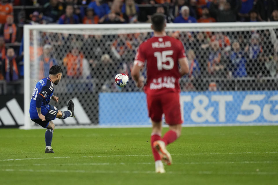 FC Cincinnati midfielder Luciano Acosta (10) scores on an open goal as New York Red Bulls defender Sean Nealis (15) looks on during the first half of an MLS playoff soccer match, in Cincinnati, Sunday, Oct. 29, 2023. (AP Photo/Carolyn Kaster)