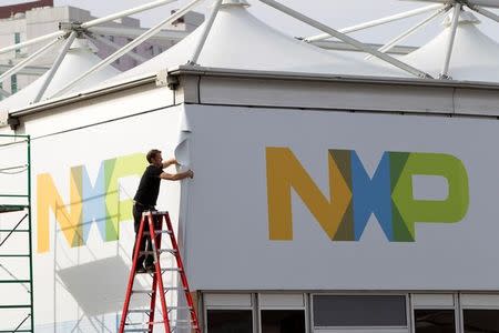 FILE PHOTO: A man works on a tent for NXP Semiconductors in preparation for the 2015 International Consumer Electronics Show (CES) at Las Vegas Convention Center in Las Vegas, Nevada, U.S. January 4, 2015. REUTERS/Steve Marcus/File Photo