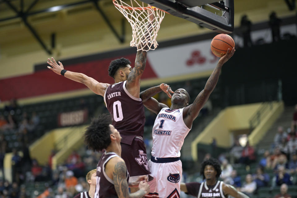 Florida Atlantic guard Johnell Davis (1) goes up for a shot as Texas A&M guard Jace Carter (0) defends during the second half of an NCAA college basketball game, Friday, Nov. 24, 2023, in Kissimmee, Fla. (AP Photo/Phelan M. Ebenhack)