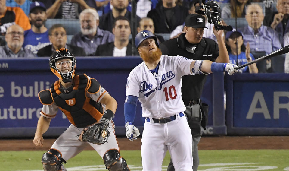 Los Angeles Dodgers' Justin Turner, center, hits a solo home run as San Francisco Giants catcher Buster Posey, left, and home plate umpire Cory Blaser watch during the fifth inning of a baseball game, Monday, Aug. 13, 2018, in Los Angeles. (AP Photo/Mark J. Terrill)