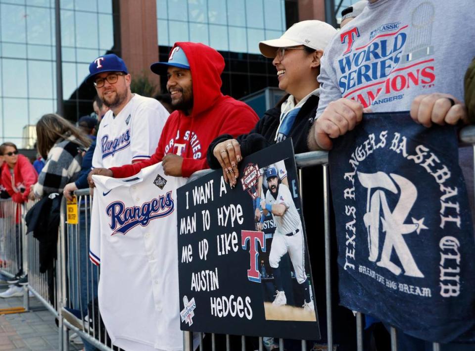 As Veronica Garcia displays her poster, Michael Doporto hopes to get his jersey autographed during the Texas Rangers World Series Parade in Arlington, Texas, Friday, Nov. 03, 2023. (Special to the Star-Telegram Bob Booth)