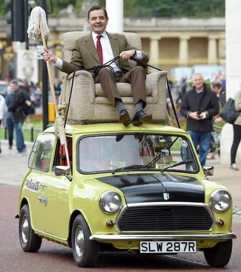 Rowan Atkinson as Mr Bean in his characteristic yellow Mini - Credit: Karwai Tang/Getty Images