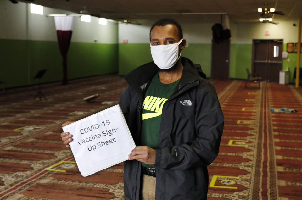 Abdiaziz Mohamed, who is in charge of coordinating vaccines for the Maine Muslim Community Center poses Wednesday, April 7, 2021 in the prayer room of the Maine Muslim Community Center in Portland, Maine. Ahead of Ramadan, Islamic leaders are using social media, virtual town halls and face-to-face discussions to spread the word that it’s acceptable for Muslims to be vaccinated during daily fasting that happens during the holy month. (AP Photo/Joel Page)