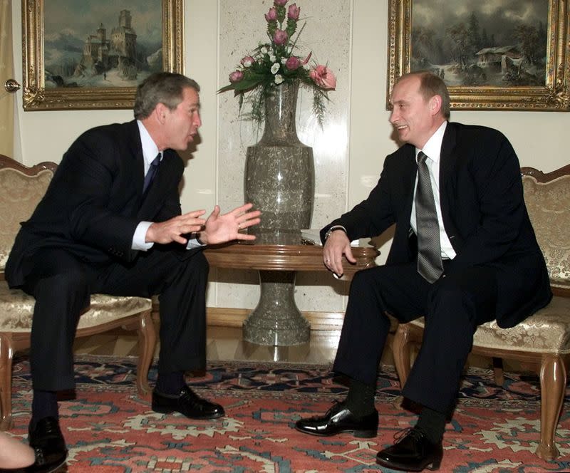 FILE PHOTO: U.S. President George W. Bush (L) gestures as he speaks to Russian President Vladimir Putin