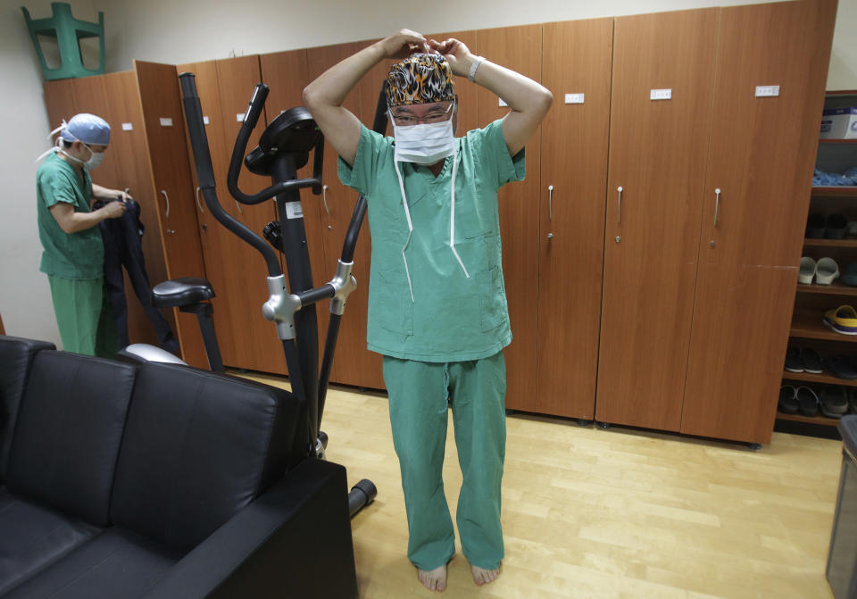 In this March 18, 2014 photo, Dr. Kim Seok-Kwun wears a mask before entering the operating room at Dong-A University Hospital in Busan, South Korea. Dr. Kim is a pioneer in slowly changing views on sexuality and gender in the country, where many have long considered even discussions of sexuality a taboo. As Dr. Kim begins what will be 11 hours of surgery meant to create a functioning penis for a Buddhist nun, he is well aware of the unease his work creates in this deeply conservative country. The devout Protestant known as the “father of South Korean transgender people” once wrestled with similar feelings. “I’ve decided to defy God’s will,” Kim said in an interview before the nun’s recent successful surgery to become a man. (AP Photo/Ahn Young-joon)