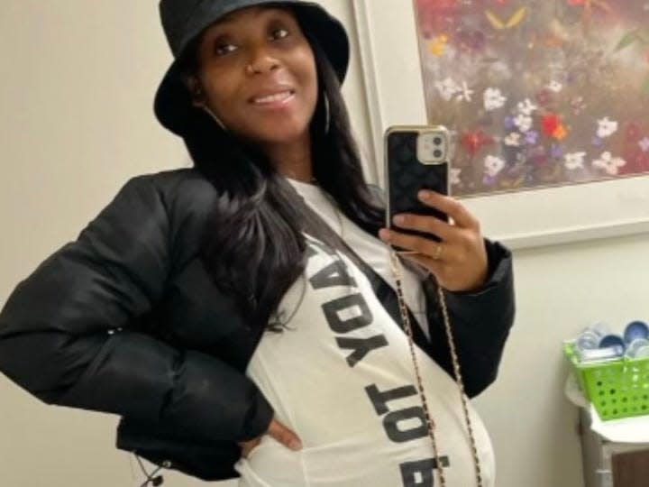 Porcha Woodruff with pregnant belly smiling