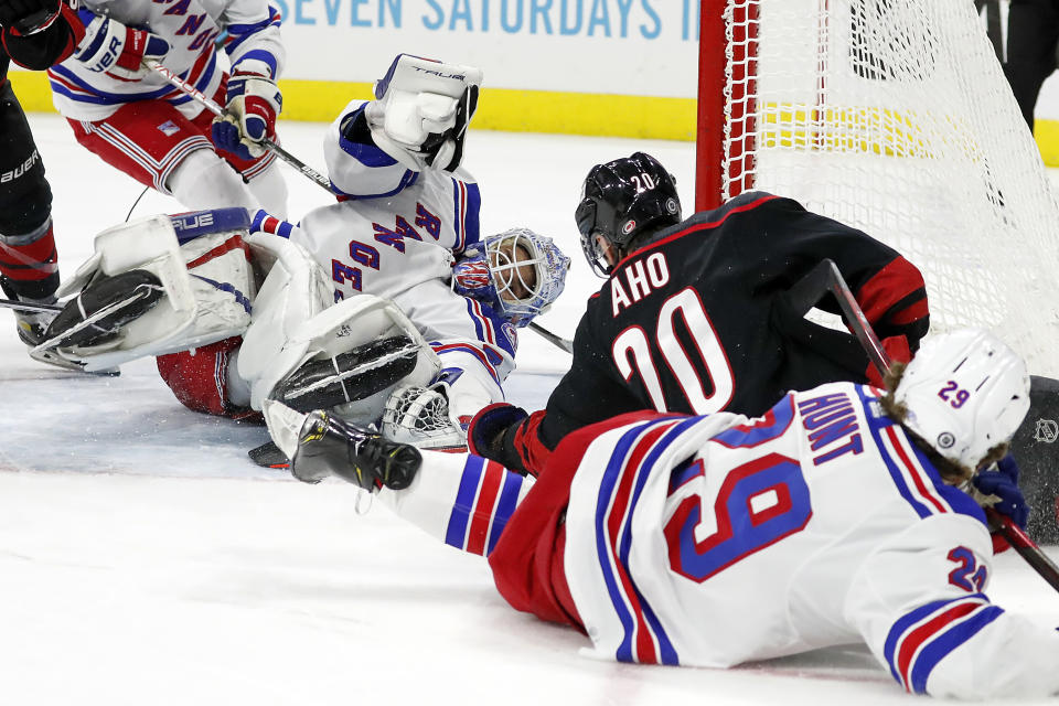 Carolina Hurricanes' Sebastian Aho (20) jams the puck past New York Rangers goaltender Alexandar Georgiev (40) for a goal during the second period of an NHL hockey game in Raleigh, N.C., Friday, Jan. 21, 2022. (AP Photo/Karl B DeBlaker)