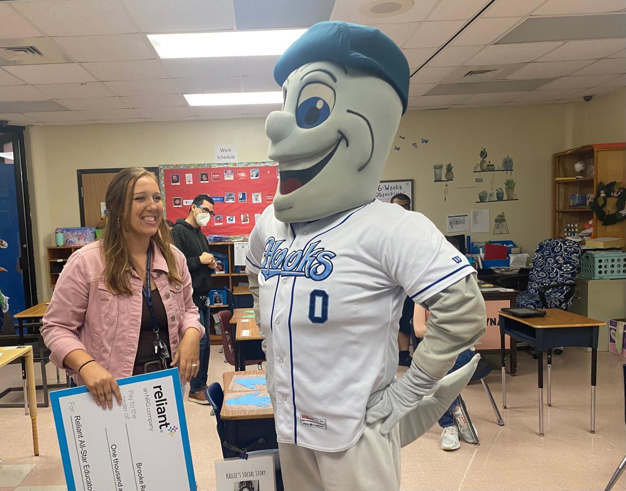 Mary Grett Transition Center adaptive education teacher Brooke Reyna, left, smiles after being presented with a surprise award of $1,500 by the Corpus Christi Hooks through the All-Star Educators Program on Wednesday at the center.