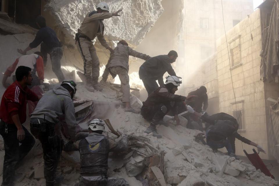 Civil defense team members try to rescue people from the wreckage of a building after the Russian military carried out airstrikes on the al-Salihiya district in Aleppo on March 11, 2016. (Ibrahim Ebu Leys/Anadolu Agency/Getty Images)