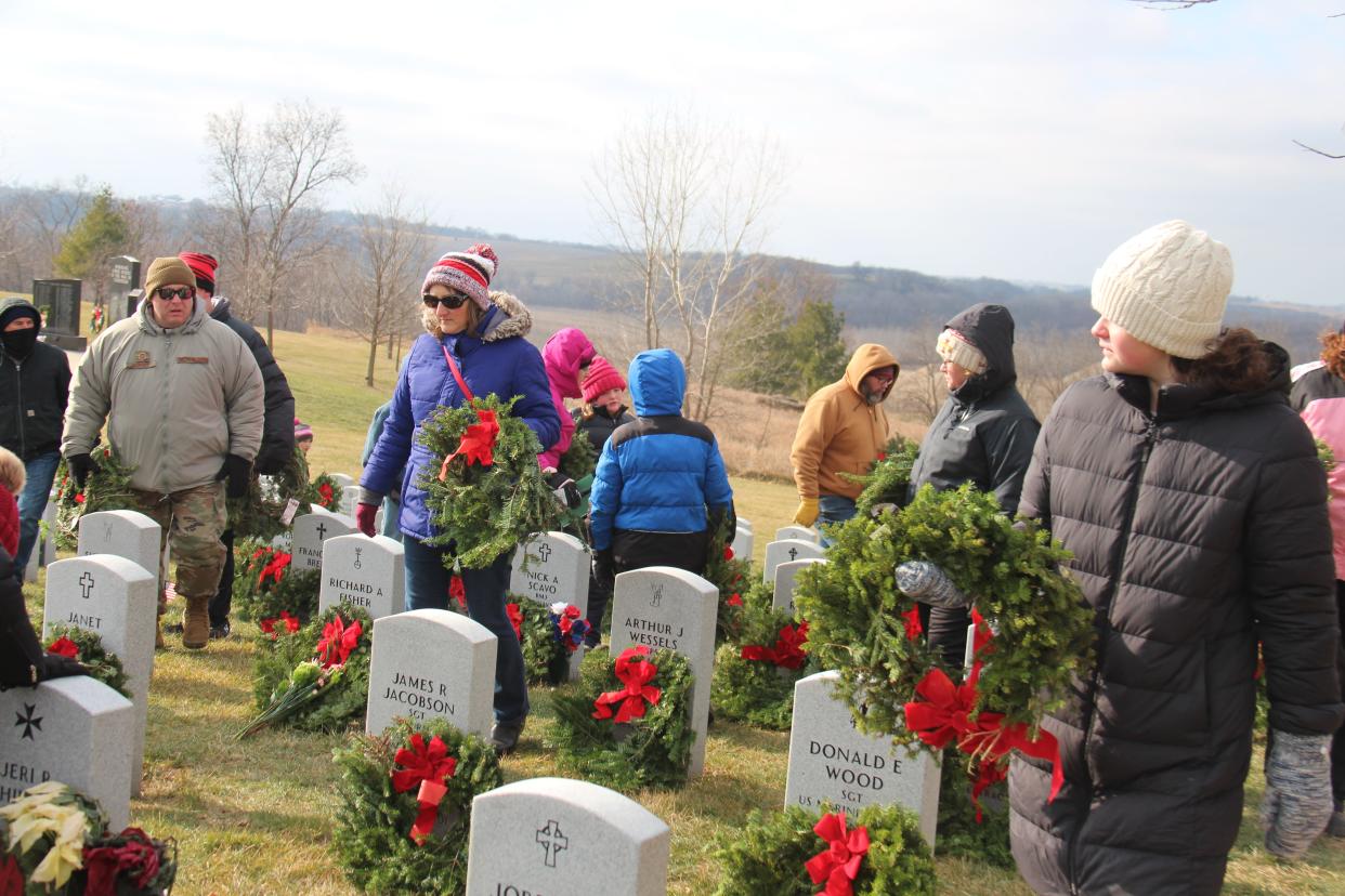 As part of Wreaths Across America, volunteers lay wreaths on the graves of fallen veterans while saying their names at Iowa Veterans Cemetery on Saturday, Dec. 18, 2021, near Van Meter.