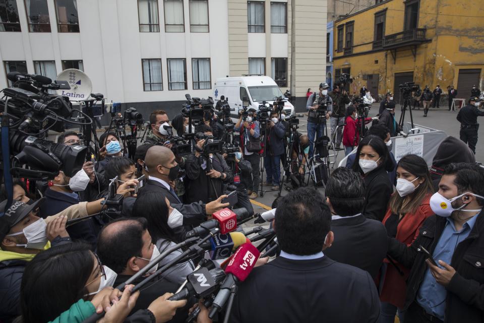 Reporters interview a lawmaker outside Congress in Lima, Peru, Friday, Sept. 18, 2020. Peruvian President Martin Vizcarra's job is on the line Friday as opposition lawmakers push through an impeachment hearing criticized as a hasty and poorly timed ouster attempt in one of the countries hardest hit by the coronavirus pandemic. (AP Photo/Rodrigo Abd)