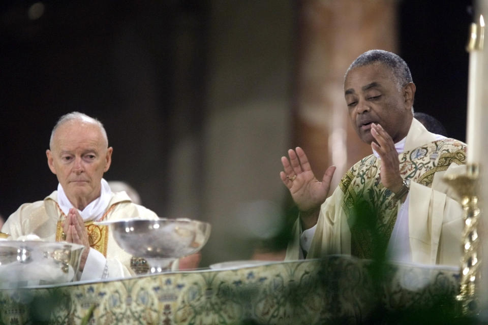 FILE - In this Sept. 11, 2002 file photo, the Rev. Wilton Gregory of Belleville, Ill., president of the U.S. Conference of Catholic Bishops, right, accompanied by Washington Cardinal Theodore McCarrick, preside over a Mass at the Basilica of the National Shrine of the Immaculate Conception in Washington, during the U.S. Bishops National Memorial Mass on the first anniversary of the terrorist attacks. (AP Photo/Terry Ashe, File)