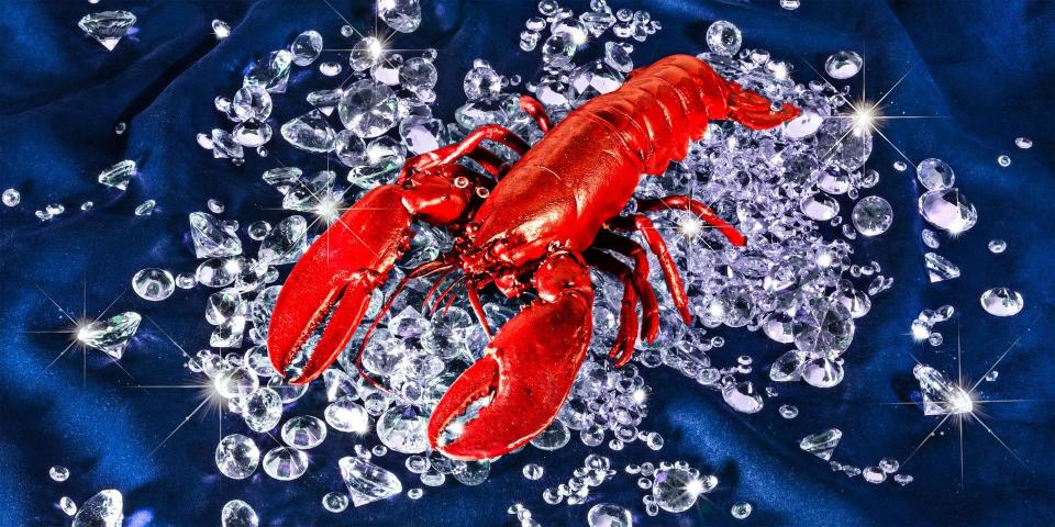 A lobster lying on a pile of diamonds.
